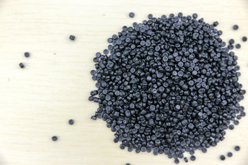Close-up of plastic polymer granules. Polymer pellets on Wooden blackground. polymer plastic. compound polymer. plastic recycle.