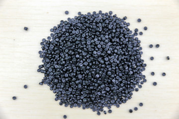 Close-up of plastic polymer granules. Polymer pellets on Wooden blackground. polymer plastic. compound polymer. plastic recycle.