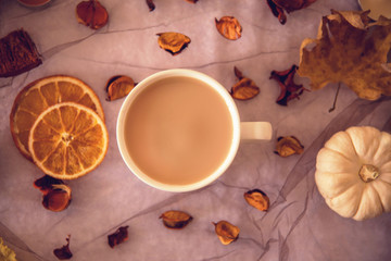A cup of latte and white pumpkin with autumn ornaments on a table, close up, still life photography