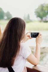 Young pretty girl's using smartphone with city on background