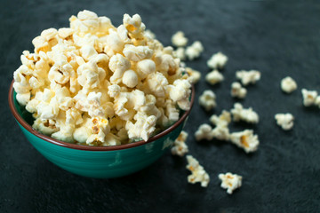 Plate with popcorn on a black background.