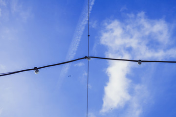 hanging electric lamps against the blue sky