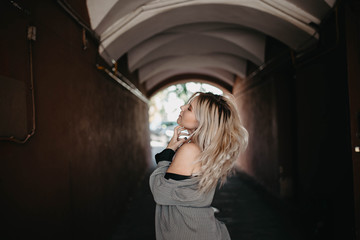 street portrait of a long-haired blonde in an arch.