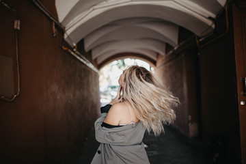 Fototapeta premium street portrait of a long-haired blonde in an arch.