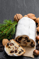 Traditional Christmas stollen fruit cake on black stone table