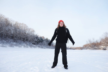 A man travels with a backpack. Winter hike in the forest. Tourist on a walk in the winter in the park.