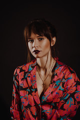 Young caucasian woman on black studio background