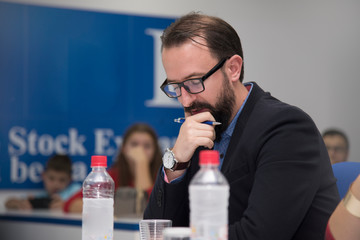 Male academic professor holding a test and examines the student. Exams and traditional education concept.