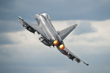 An RAF Typhoon takes off fully loaded with weapons on its wings to perform a display at an Airshow - obrazy, fototapety, plakaty