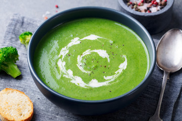 Broccoli cream soup in a bowl with toasted bread. Close up.
