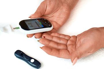 A diabetic checks his blood sugar. The woman is self-tested with a Lancet and a glucometer at home.