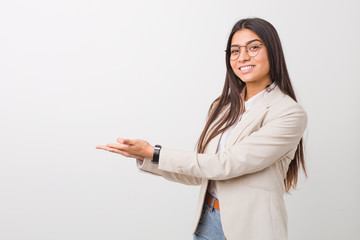 Young business arab woman isolated against a white background holding a copy space on a palm.