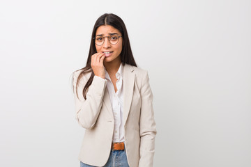 Young business arab woman isolated against a white background biting fingernails, nervous and very...