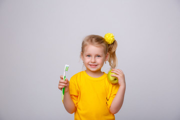 girl the blonde on a yellow background with a toothbrush
