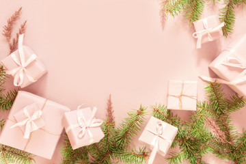 Christmas pink flat lay. Holiday boxes, fir branches on pink background. Christmas winter holiday congratulation invitation birthday wedding