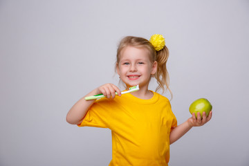 girl the blonde on a yellow background with a toothbrush