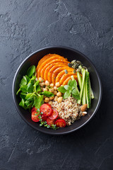 Healthy vegetarian salad. Roasted pumpkin, quinoa, tomatoes, green salad. Buddha bowl. Slate...