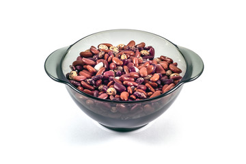 Multi-colored beans in a black transparent plate on a white background