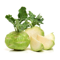 A vertical picture of a pretty two toned green kohlrabi with gracefully furled leaves on an...