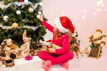 beautiful girl decorating her Christmas tree