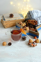 Obraz na płótnie Canvas cup of tea or tea and rock Candy sugar crystal sticks, sweater, nuts, books. fall or winter season concept. tea time. home hygge comfort concept. copy space
