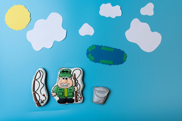 Fisherman with two fishing rods and a bucket. Lake and clouds.