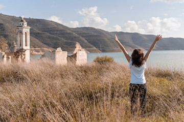 Beautiful tourist girl look on the Scenic landscape of Kouris reservoir large artificial lake and...