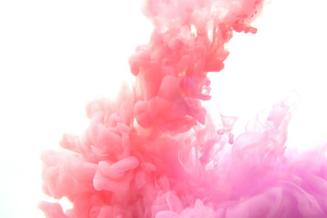 Mix of abstract red and violet ink in water on a white background. It looks like smoke or cloud. Or...