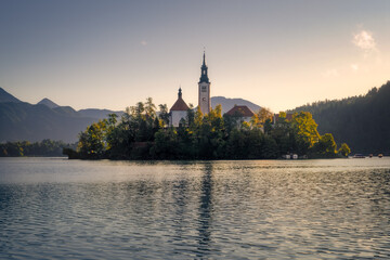 Fototapeta na wymiar Scenic view of Lake Bled island with church and colorful autumn foliage, Slovenia