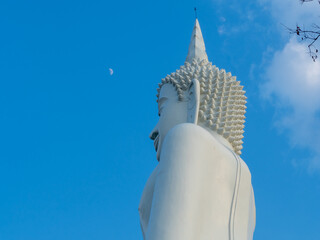 White buddha staue and blue sky with moon