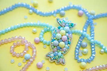 Handmade candy brooch in pastel colors, fashion jewelry, girl and women accessory on yellow background, flat lay with beads, pearls and crystals