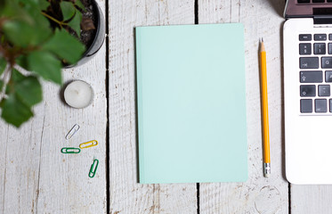 Cozzy workplace with candle, plant, notebook, pencil and paper notes