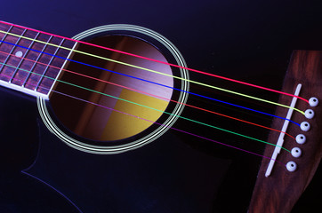 Obraz premium Black acoustic guitar with multi-colored strings. Close-up.