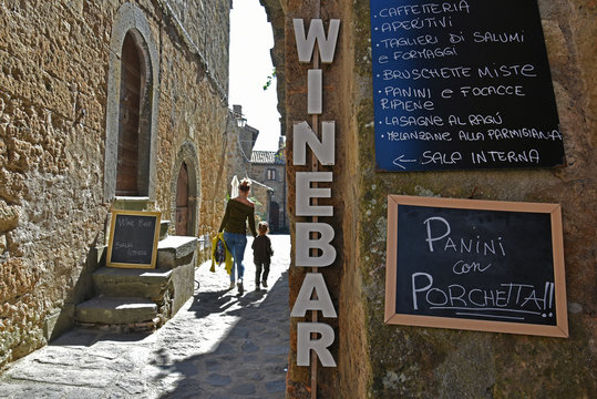 Fototapeta Civita di bagnoregio in Lazio with closeup of sign for Wine Bar in in small town village stone wall.