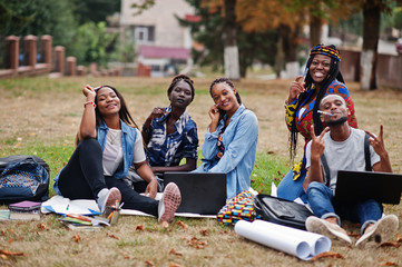 Group of five african college students spending time together on campus at university yard. Black...