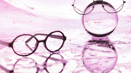 Tools for vision correction. Glasses and lenses with diopters on the background of splashes and...