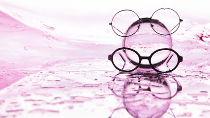 Tools for vision correction. Glasses and lenses with diopters on the background of splashes and...