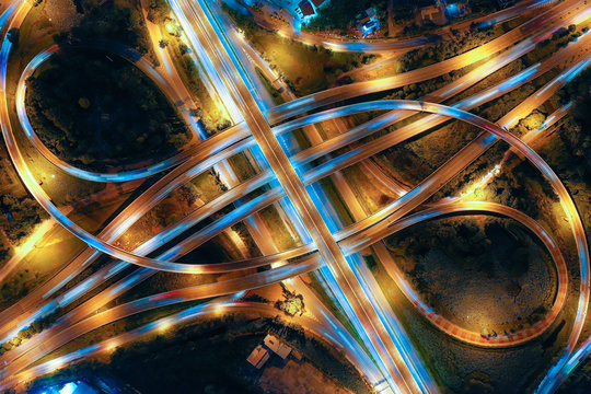 Aerial view of Smart transportation with Expressway, Road and Roundabout, busy highway traffic night time. Important infrastructure.