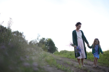 Obraz premium Mother with daughter walking on a road
