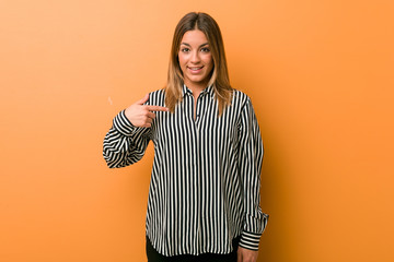 Young authentic charismatic real people woman against a wall person pointing by hand to a shirt...