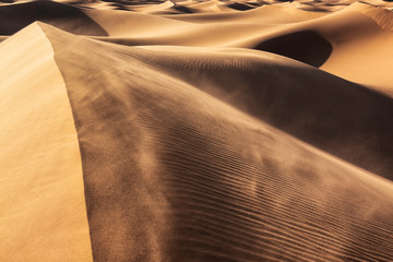 Wind blows sand into the air at the sand dunes of Erg Lihoudi.