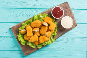 Chicken nuggets in plate on rustic background