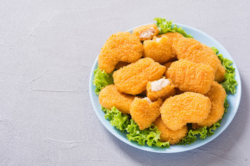 Chicken nuggets in plate on rustic background