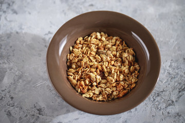 Fitness breakfast. Baked granola in a plate, close-up. Muesli, top view.