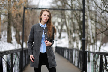 Young adult girl in coat on the street