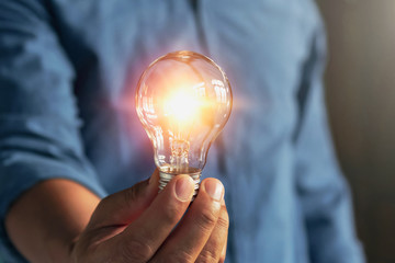 businessman hand holding lightbulb. idea Alternative energy concept saving electricity