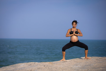 Fototapeta na wymiar Asian pregnant woman yoga on the beach sunset summer time