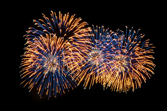 Yellow and blue sparkles of festive fireworks on a contrasting black background