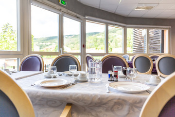 Tables servies dans salle à manger lumineuse d'une structure d'accueil maison de retraite