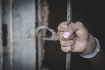 Handcuffed hands of a prisoner in prison,   Male prisoners were severely strained in the dark...